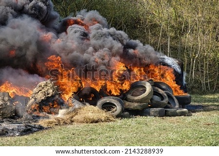 Burning landscape. Vehicle tires and haystacks on fire, black smoke invading the landscape...demonstrations against the environment Royalty-Free Stock Photo #2143288939