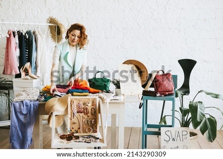 middle aged woman female woman at swap party try on clothes, bags, shoes and accessories, change clothes, second hand garment, zero waste life, eco-friendly approach to consumption, diverse people Royalty-Free Stock Photo #2143290309