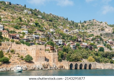 View of the coastline in Alanya, Turkey. View with stone arches of medieval Tersane shipyard. Tersane dates from 1221 and is the only Seljuk-built shipyard remaining in Turkey.  Royalty-Free Stock Photo #2143295877