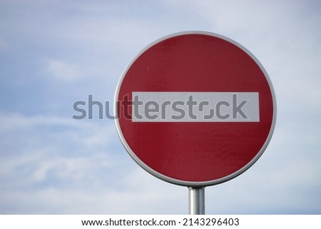 Close-up photo of a No Entry Sign with the sky in the background