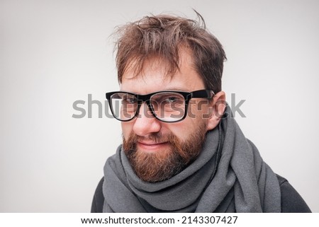 Smiling bearded man in glasses and grey scarf with disheveled hair Royalty-Free Stock Photo #2143307427