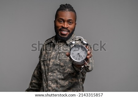 Serviceman in a khaki uniform demonstrating a timepiece Royalty-Free Stock Photo #2143315857