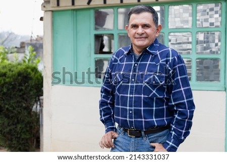 Portrait of Hispanic man in the patio of his house - Latino man in his 50s smiling Royalty-Free Stock Photo #2143331037