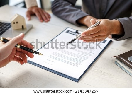 Real-estate agent sign for home contract property for sale in the office with buyer.