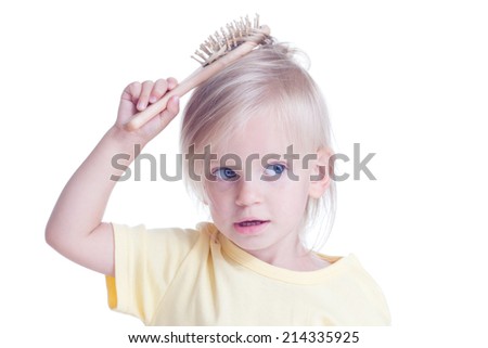 Little girl combing hair on white background