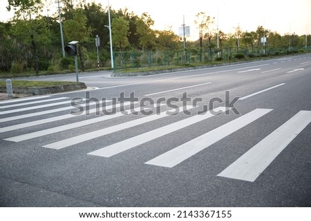 pedestrian crossing, white stripes on black asphalt, road markings zebra crossing, place to cross the road, traffic rules Royalty-Free Stock Photo #2143367155
