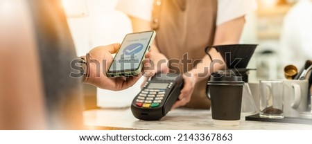Businessman using mobile payment technology to pay bill in coffee shop.man with manicure holding smartphone and using contactless payment system.new normal lifestyle concept Royalty-Free Stock Photo #2143367863