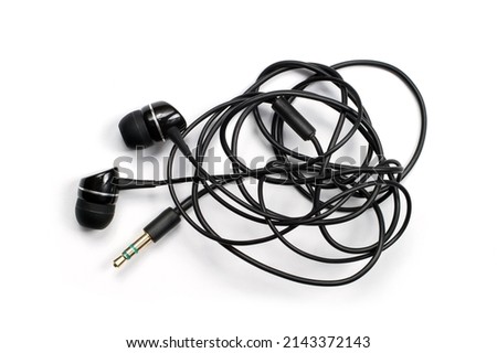Headphones with a tangled wire on a white background. Tangled headphone wire. Royalty-Free Stock Photo #2143372143