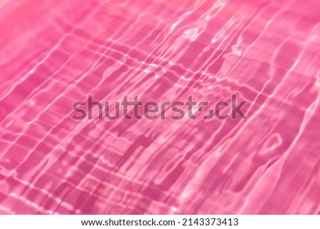 Closeup of pink transparent clear calm water surface texture with splashes and bubbles. Trendy abstract summer nature background. for a product, advertising, text space.