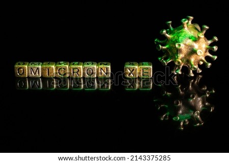 XE. A new variant of SARS-CoV-2 coronavirus. Omicron sub variant. Viral gold color on a black background Royalty-Free Stock Photo #2143375285