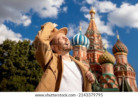 Young man traveler in brown hat makes selfie photo on background of Kremlin red square. Concept travel to Russia.