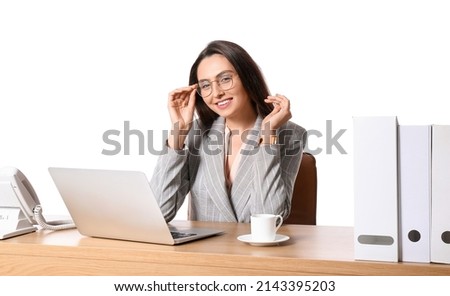 Young secretary with laptop at table on white background