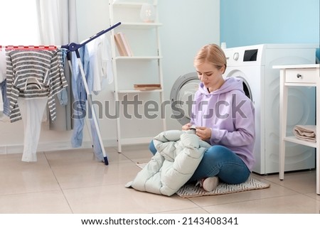 Young woman with down jacket in bathroom Royalty-Free Stock Photo #2143408341
