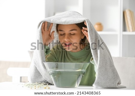 Young woman doing steam inhalation at home to soothe and open nasal passages Royalty-Free Stock Photo #2143408365
