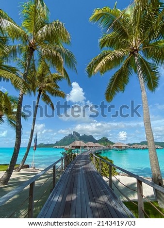 View of the Mount Otemanu through turquoise lagoon, palm trees and overwater bungalows on Bora Bora island, Tahiti, French Polynesia, South Pacific Royalty-Free Stock Photo #2143419703