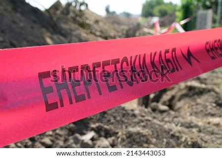 Red ribbon on a construction site. Energetski kabl Translation: "Power cable".