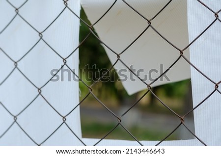 The banner is attached to Chain-link fencing. White banner with perforated wind holes. Special holes to reduce resistance to wind flow and increase durability.