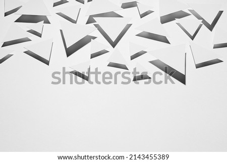 White flying triangles geometric pattern in hard light with strict black shadows in random as border, copy space, top view. Minimalist sharp energetic modern abstract background.