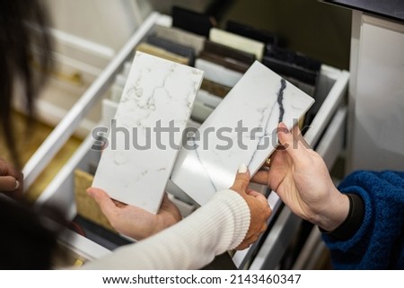 Closeup hands creative female interior designer and customer choosing marble stone color for kitchen or facades. Top view woman client consulting to decorator choice home improvement materials Royalty-Free Stock Photo #2143460347