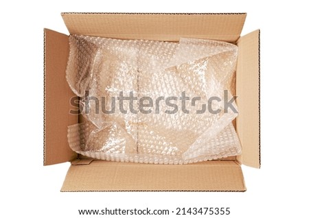 An open cardboard box with bubble wrap. The concept of packaging parcels with fragile cargo. Isolated on white Royalty-Free Stock Photo #2143475355