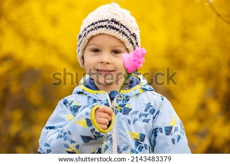 Beuatiful child, toddler boy, holding pink paper flower, handmade for mom for Mothers day
