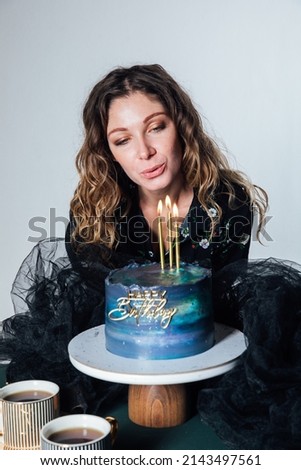 woman blows on candles festive cake for birthday