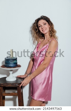 a woman holds a festive birthday cake