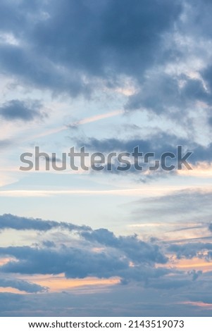 Cover page with deep blue sky with illuminated clouds at soft orange sunset as a background