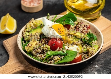 Keto diet plate quinoa, avocado, egg, tomatoes, spinach and sunflower seeds on dark background. Healthy food, ketogenic diet, diet lunch concept, Food recipe background. Close up. Royalty-Free Stock Photo #2143520093