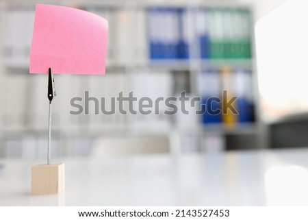 Pink blank note sticker on desk in office closeup