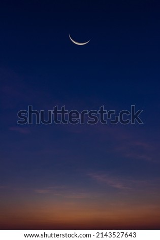 Crescent moon on dusk sky vertical Twilight after sundown symbol of religion islamic in Ramadan Kareem month space for text Eid al Adha, Eid Al Fitr Royalty-Free Stock Photo #2143527643