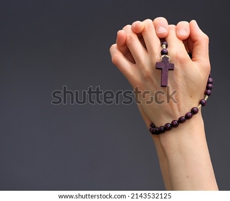 hand holding cross praying to god stock photo  Royalty-Free Stock Photo #2143532125