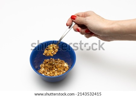 female hand holds a spoon with cereal over a cup. High quality photo
