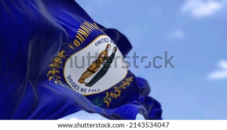 The US state flag of Kentucky waving in the wind. Kentucky is a state in the Southeastern region of the United States. Democracy and independence. Royalty-Free Stock Photo #2143534047