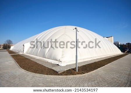 Inflatable air dome stadium. Inflated Tennis air dome or Tennis bubble arena. Modern urban architecture example as pneumatic stadium dome. Royalty-Free Stock Photo #2143534197