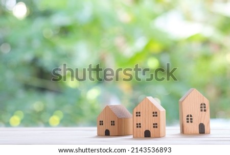 home and life concept. Small model house on green background with sunlight abstract background. Vintage tone filter effect color style. Ecology environment concept and copy space for text.