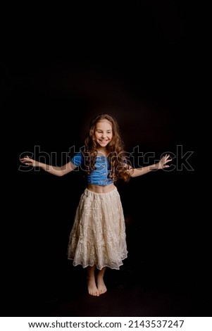 nine-year-old girl dressed in an outfit for dancing, on a black background