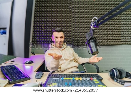 emotional professional radio host on broadcasts live, reading news and messages from radio listeners into a studio microphone on a radio station