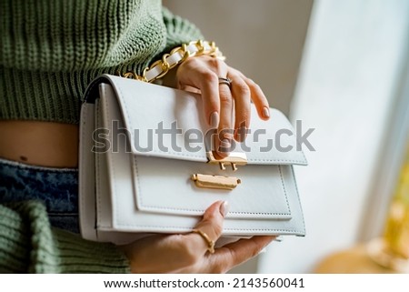 Trendy outfit woman with black bag. Girl with bag over his shoulder outdoors. Shoulder Bags for Women. Fashion look woman outfit. Stylish women's beige handbag. Close-up. Royalty-Free Stock Photo #2143560041
