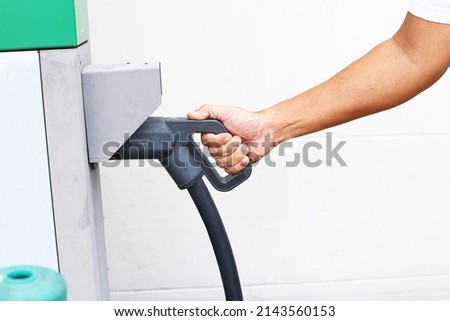 Man Hand Using Electric car charger EV battery commuter station spot.