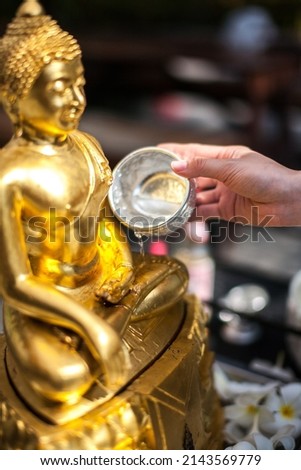 Sprinkle water onto a Golden Buddha Statue in Songkran Festival, is New Year of Thailand's most famous festival Royalty-Free Stock Photo #2143569779