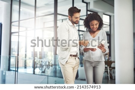 Without communication, collaboration is impossible. Shot of two businesspeople discussing something on a digital tablet. Royalty-Free Stock Photo #2143574913
