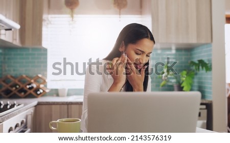 I think I bit my gum thats so painful. Shot of a young businesswoman suffering from a tooth ache while eating an apple at home. Royalty-Free Stock Photo #2143576319
