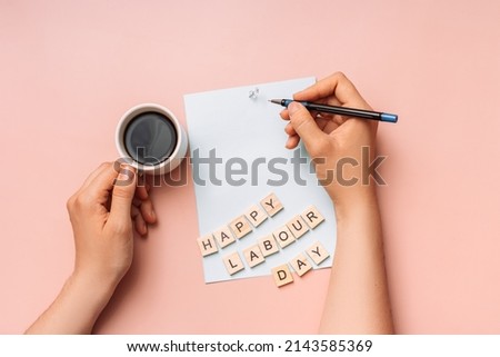 Hands holding pen and cup of coffee on paper.