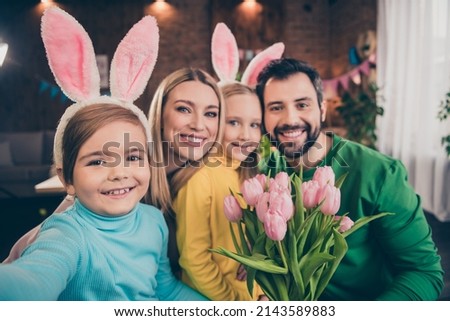 Portrait of cute family little son take selfie with bunny ears celebrate easter give mom and sister bunch of tulips spend time indoors