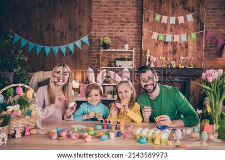 Photo of adorable cute family relaxing indoors paint easter eggs together mommy and daddy helping their kids