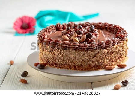 Traditional cake with buttercream, almonds and coffee beans in chocolate, selective focus. Copy space. Concept of traditional vintage cakes.