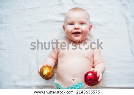 Cute baby 7 months old and Christmas balls. My first Christmas concept. Selective focus.