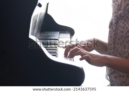 Children's hands of a pianist close-up. school-age child plays the piano. Backlight