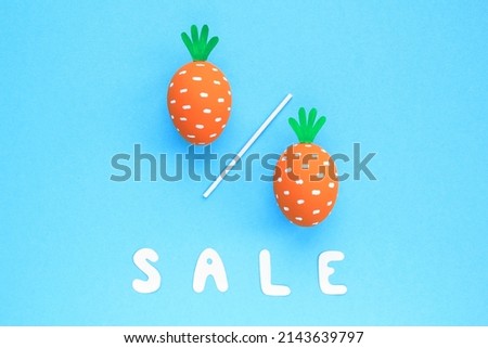 Colourful eggs with funny carrots and lettering Sale on blue background. Easter sale banner with percentage sign. Top view, flatlay creative concept for advertising, poster, magazine, web